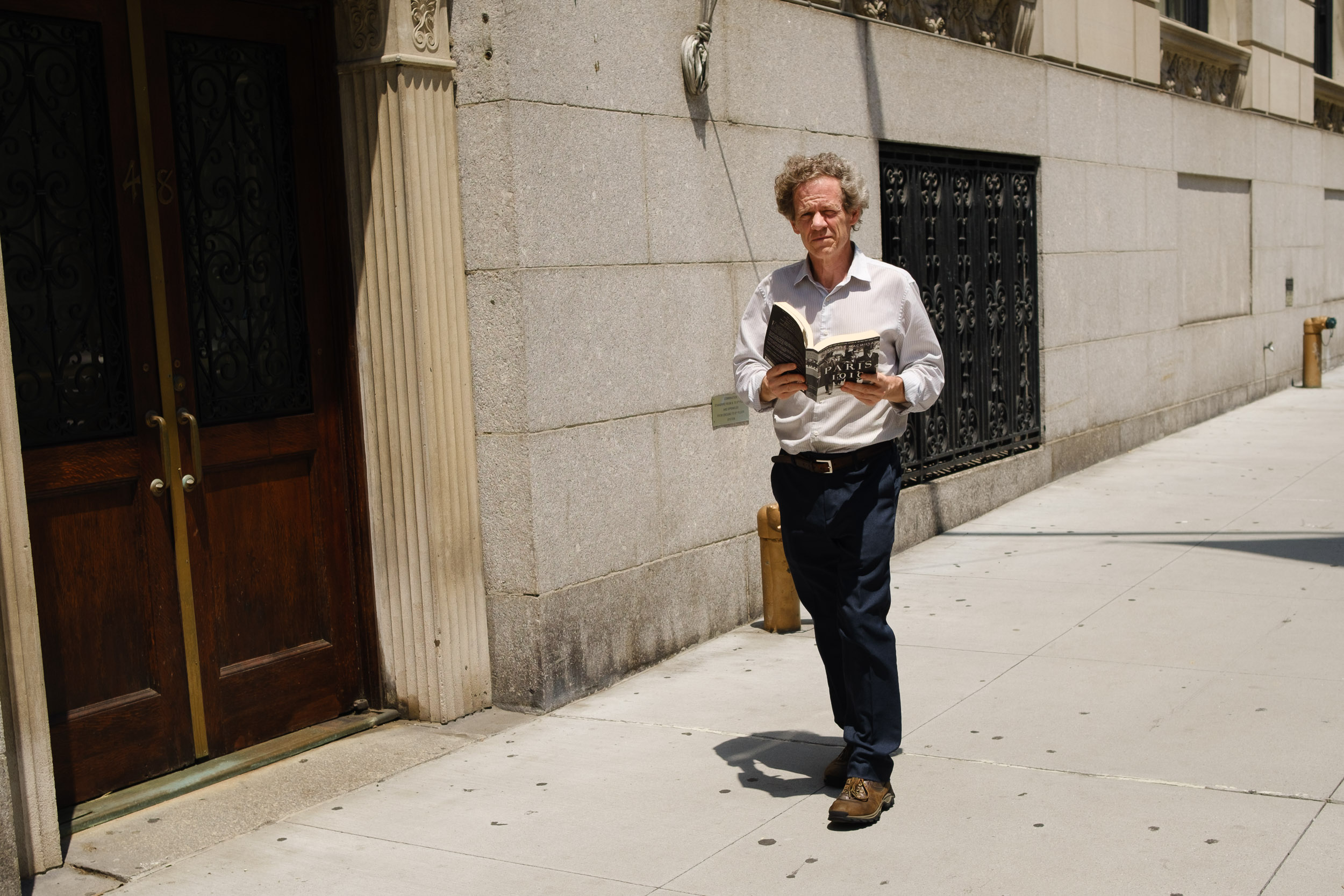 Person walking while reading a book Park Avenue New York 
